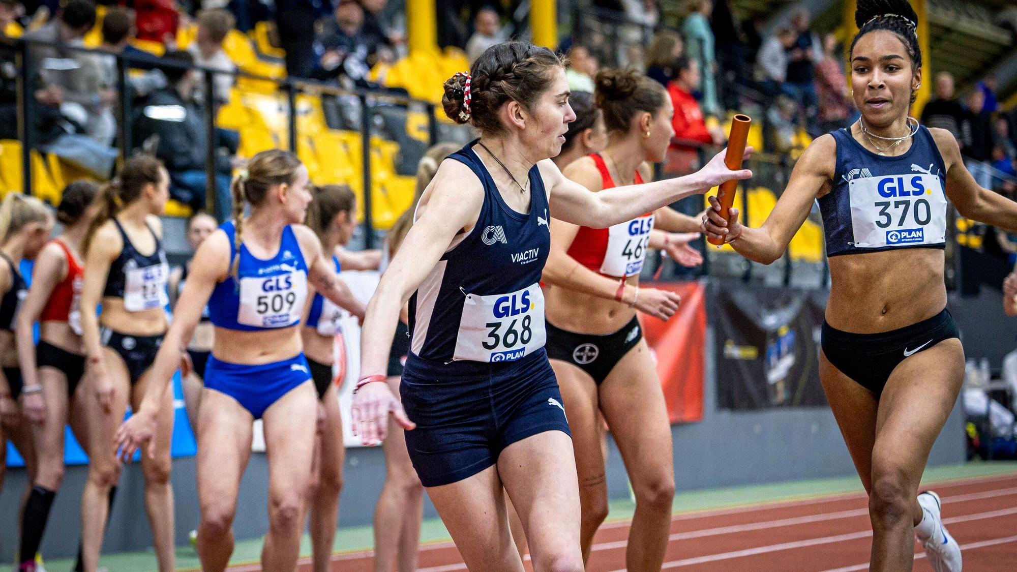 Natalie Füllgraf von den Cologne Athletics übergibt den Staffelstab in Führung liegend an Vera Coutellier, die den Vorsprung ins Ziel bringt.