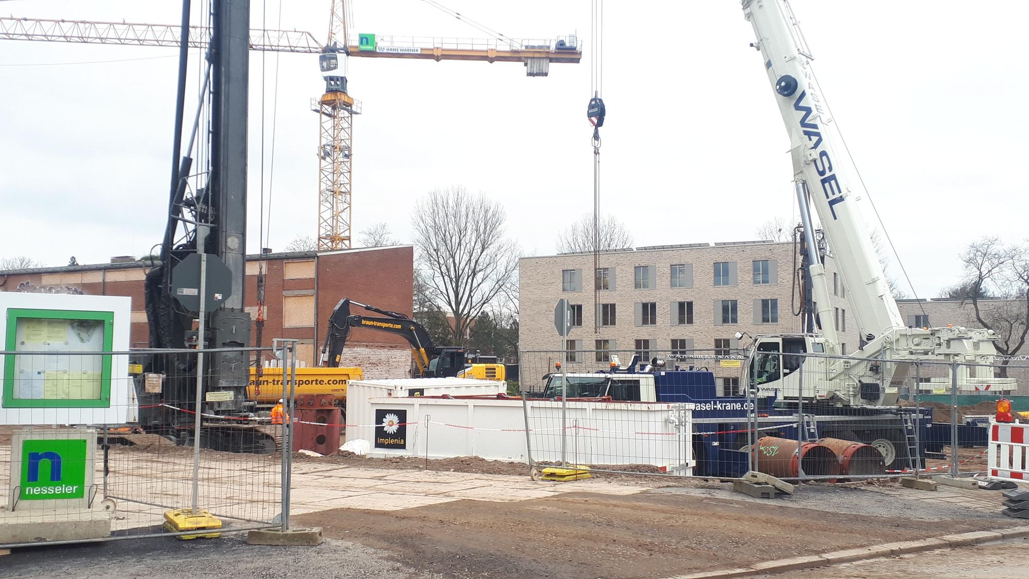 Man schaut auf eine große Baustelle mit Baggern.