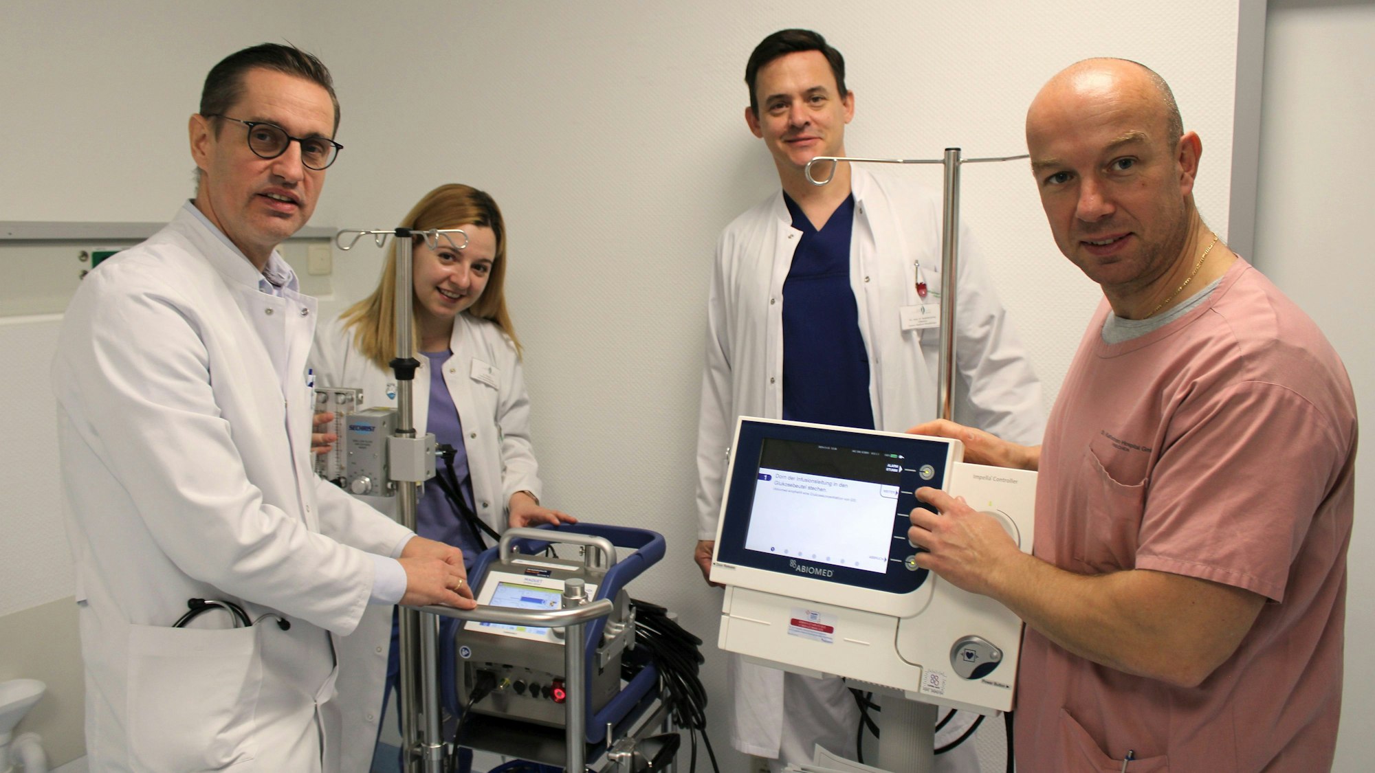 Auf dem Bild sind vier Ärzte und medizinische Geräte zu sehen.