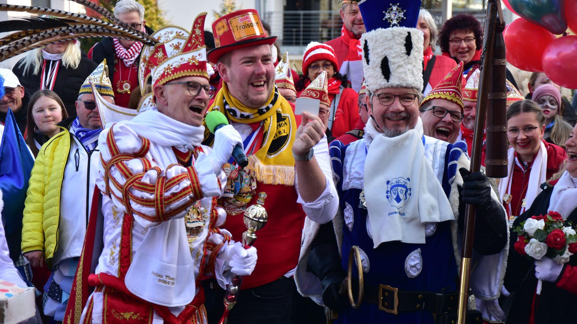 Menschen in Karnevalskostümen, vorne ein Karnevalsprinz und der Bauer aus einem Dreigestirn.