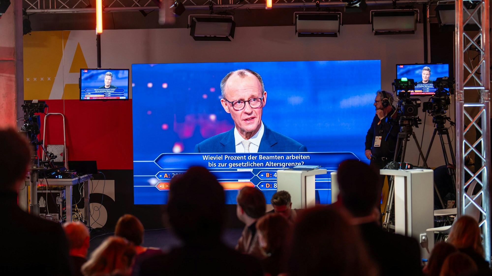 16.02.2025, Berlin: Beobachter verfolgen das ·Quadrell", die TV - Runde im Bundestagswahlkampf mit Bundeskanzler Scholz (SPD), Unionsfraktionschef Merz (CDU), AfD Kanzlerkandidatin Weidel und Grünen-Kanzlerkandidat Habeck bei den Fernsehsendern RTL und NTV. Foto: Michael Kappeler/dpa +++ dpa-Bildfunk +++