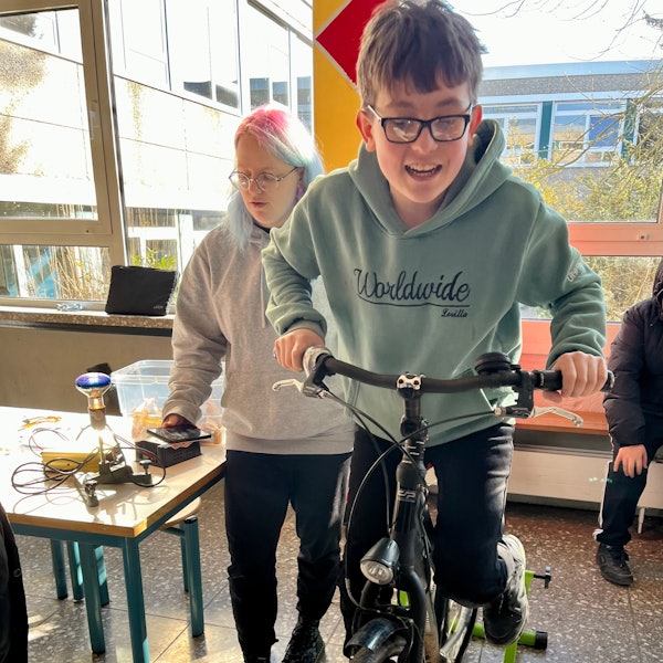 Junge auf Fahrrad zur Stromerzeugung