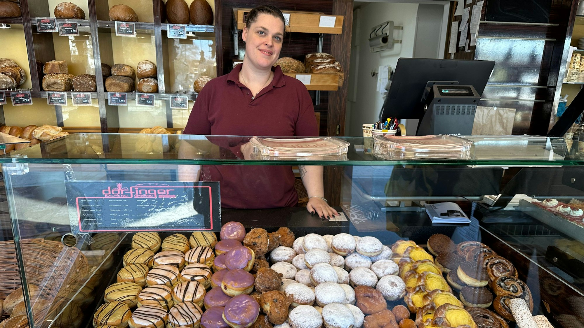 Constance Dorfinger in ihrem Bäckergeschäft vor einem Berg bunter Berliner