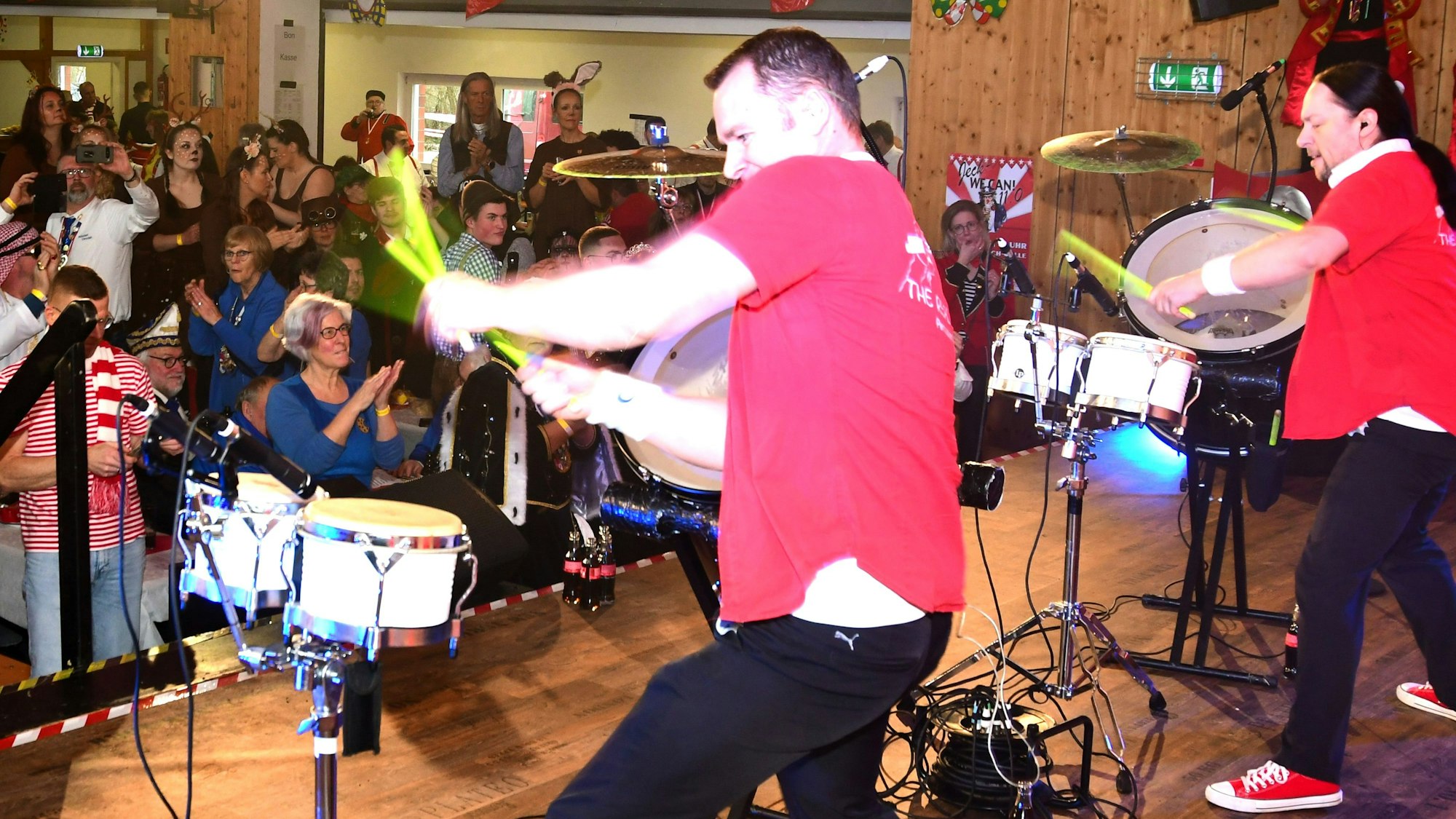 Zwei Trommler spielen auf der Bühne, das Publikum klatscht mit.