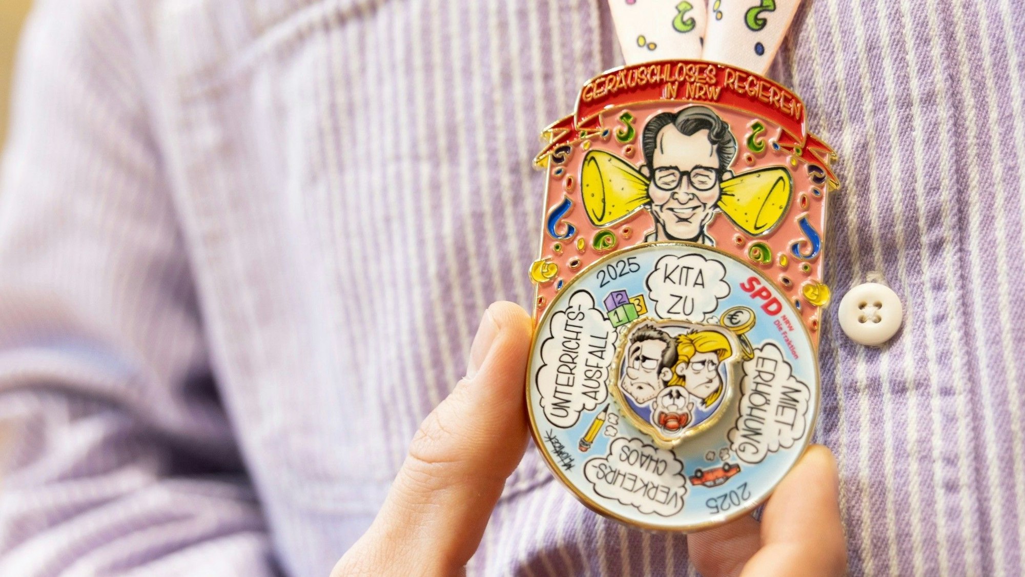 Regierungschef Hendrik Wüst (CDU) mit verstopften Ohren: Diesen Orden verteilt die SPD-Landtagsfraktion an die Jecken.