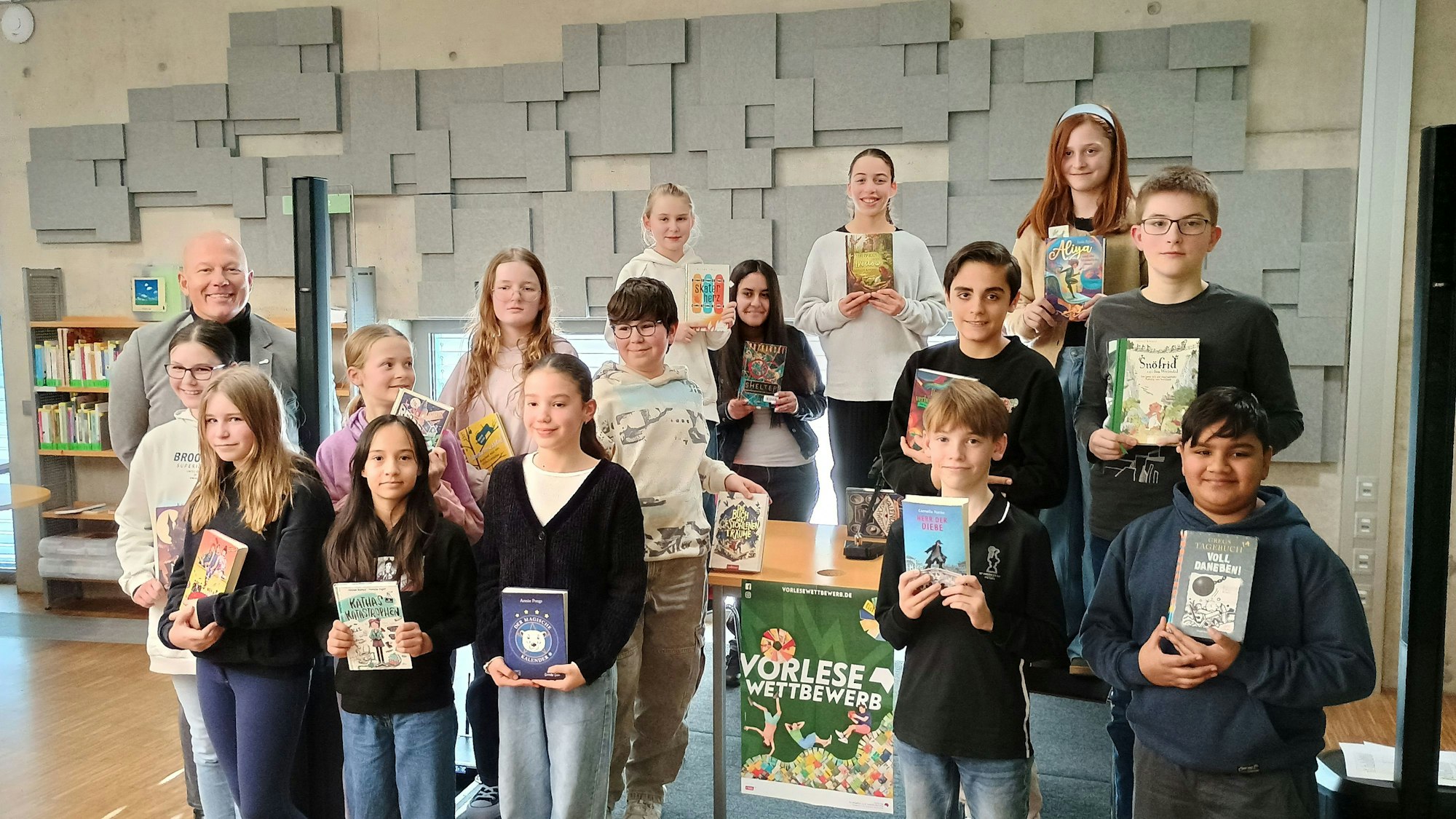 Die Kinder stehen in mehreren Reihen und halten die Bücher vor sich, aus denen sie für den Vorlesewettebewerb lasen.