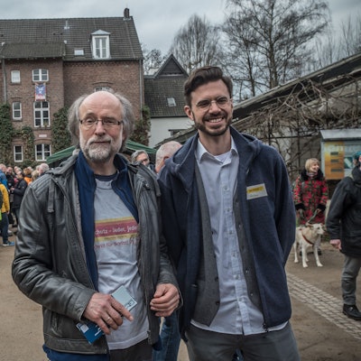 Zwei Männer stehen inmitten vieler Leute auf dem Naturgut Ophoven.