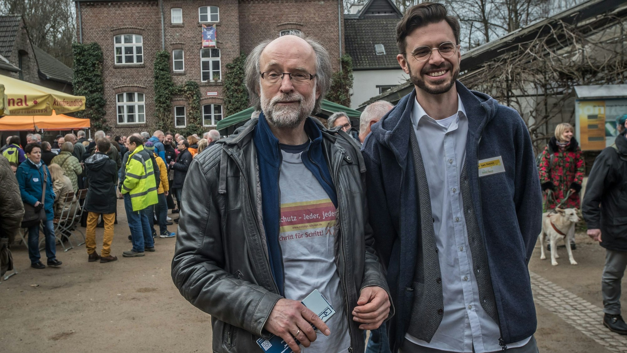 Zwei Männer stehen inmitten vieler Leute auf dem Naturgut Ophoven.