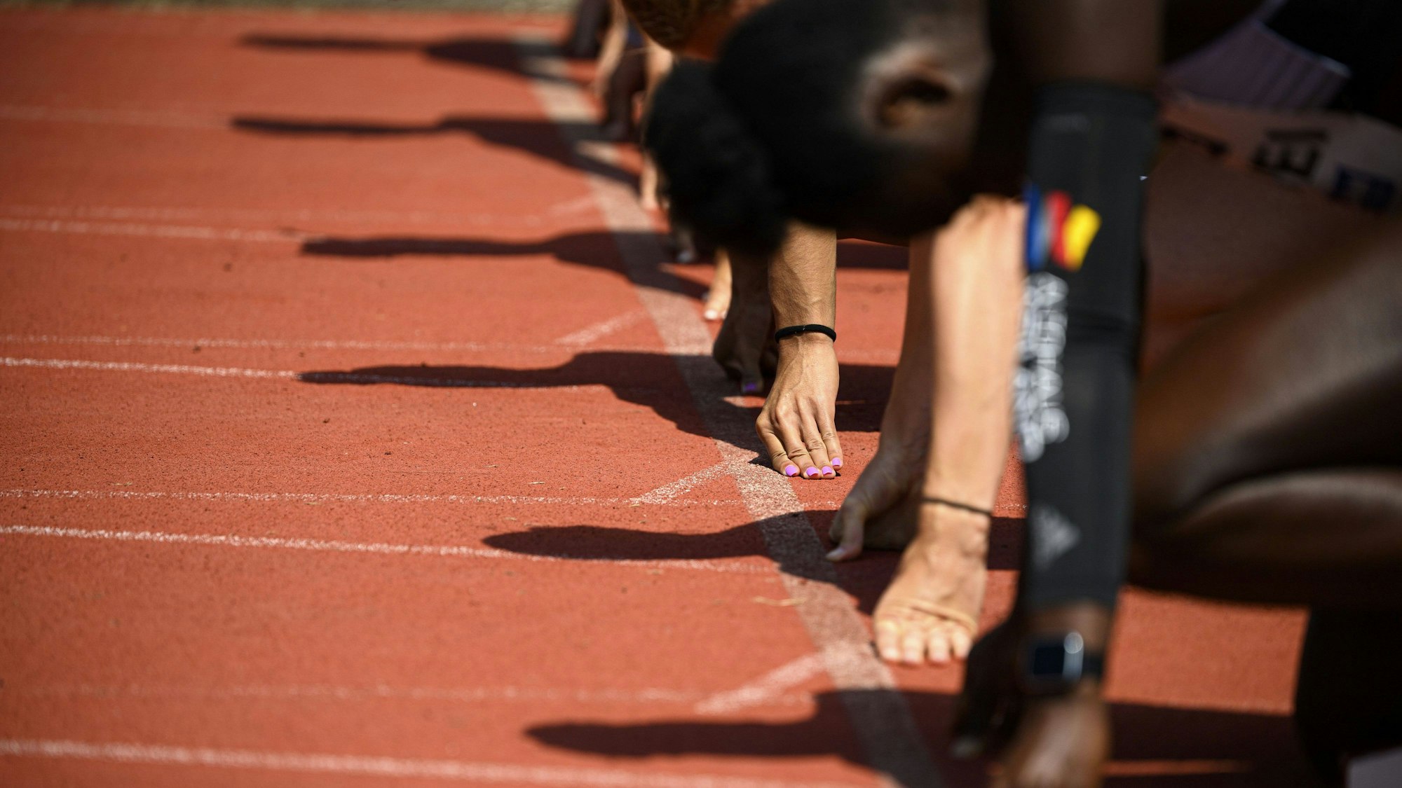 Das Bild zeigt Sportler im Startblock zu einem Lauf.