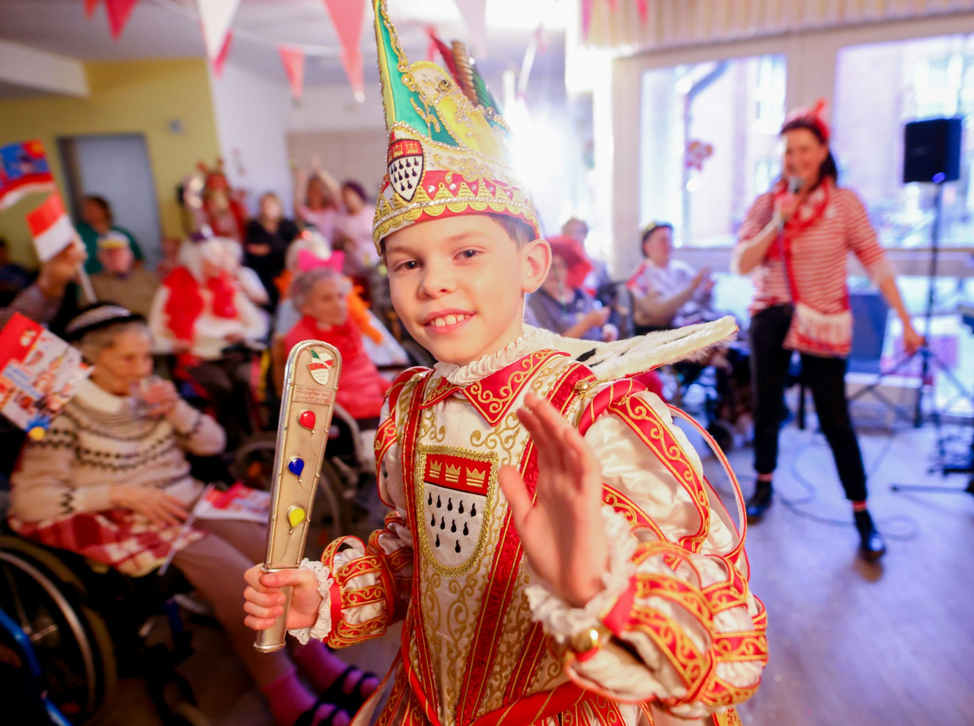 Kinderprinz Ole marschiert nach der Seniorensitzung winkend aus dem Saal.