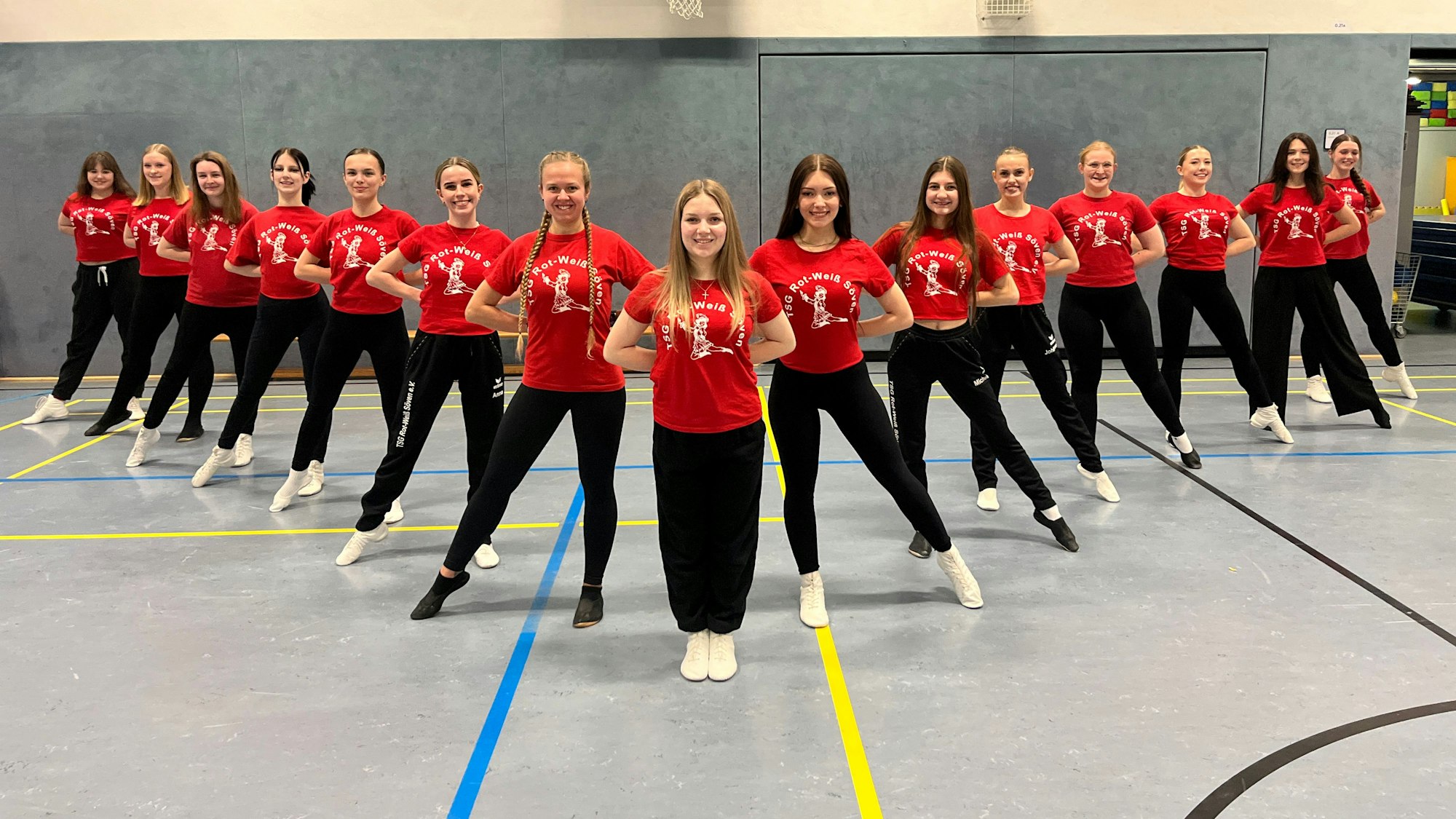 15 junge Frauen üben eine Tanzformation.