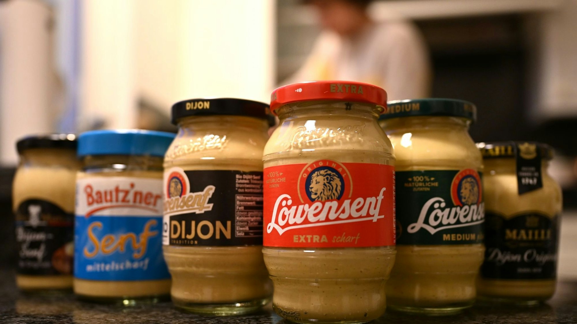 Drei Senfsorten von Löwensenf, umrahmt von Konkurrenzprodukten.