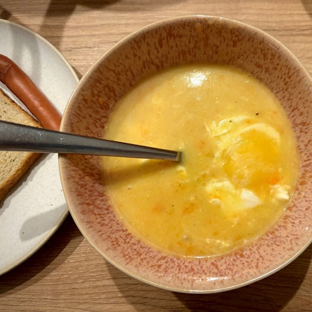Die einfache Kartoffelsuppe nach dem Rezept von Jennifer Kuschel in einer Schale mit Suppenlöffel. Sie wird in Teilen püriert - und am Ende kommt noch ein Ei hinein.