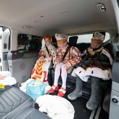 Kinderdreigestirn auf der Rückbank im kleinen Bus.
