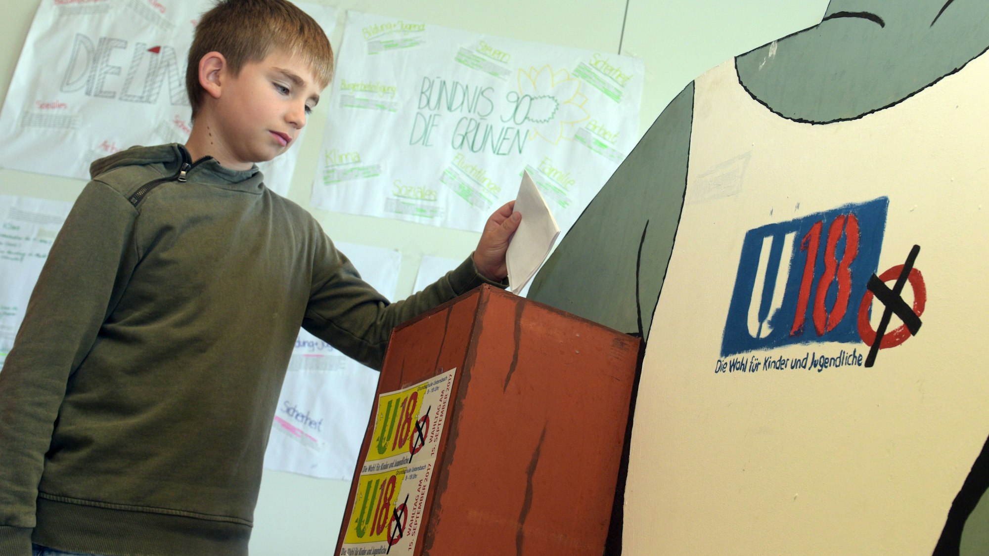 Ein junger Schüler wirft bei der U18-Wahl seinen Stimmzettel in die Urne. Analog zur Bundestagswahl findet die Jugendwahl statt, bei der Nicht-Wahlberechtigte unter 18 Jahren abstimmen können.