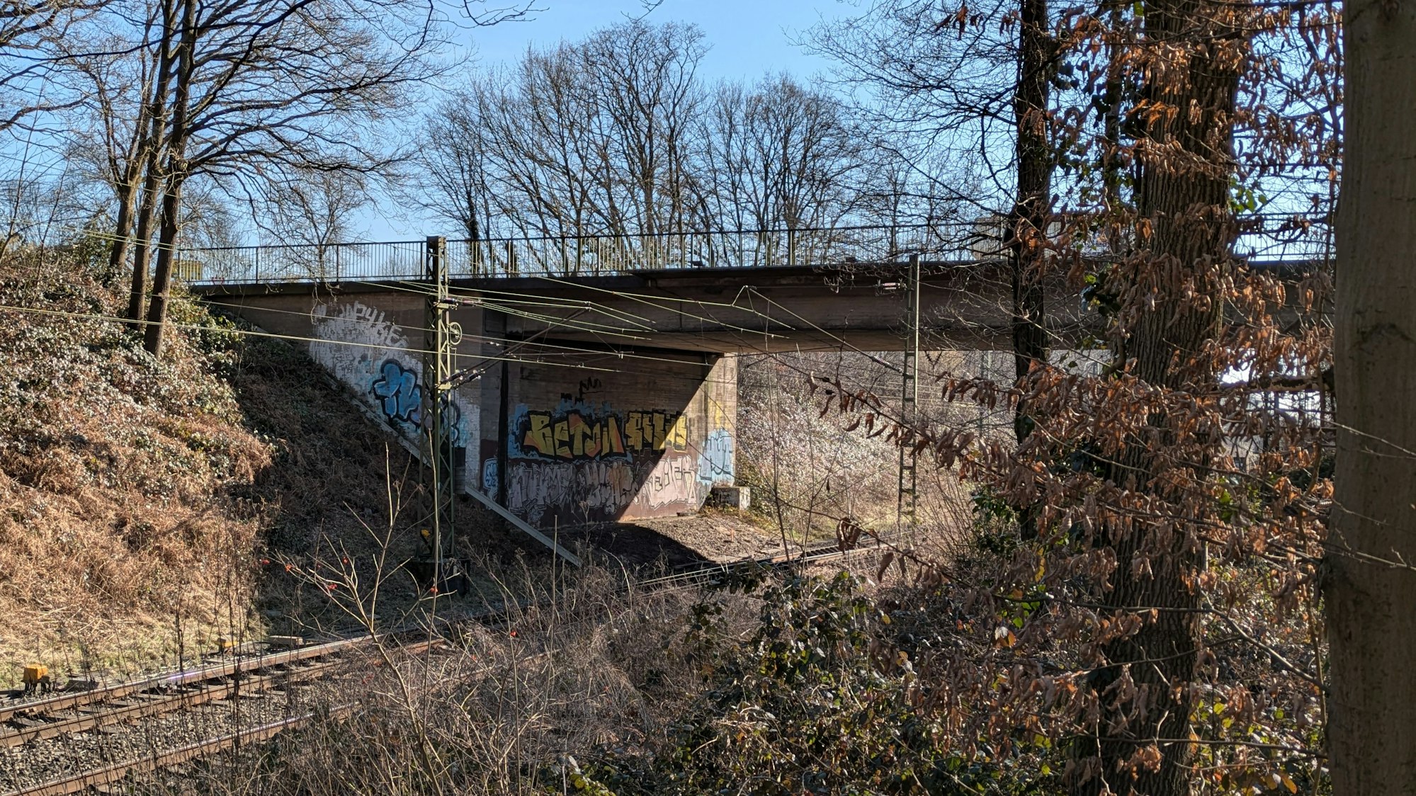 Eine Brücke führt über Bahngleise.