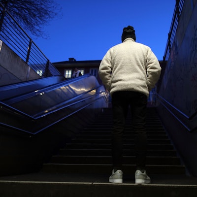 Sedat lebt in Kalk und will anonym bleiben. Er ist von hinten auf einer Treppe zu sehen.
