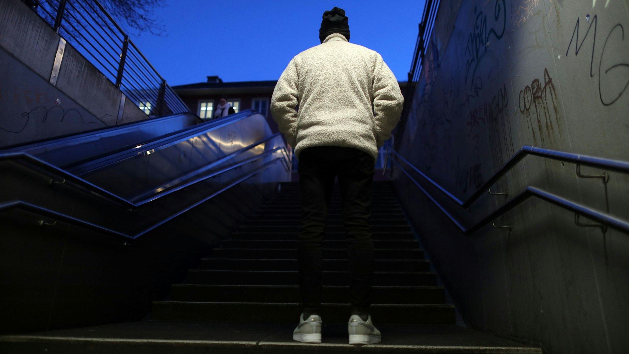 Sedat lebt in Kalk und will anonym bleiben. Er ist von hinten auf einer Treppe zu sehen.