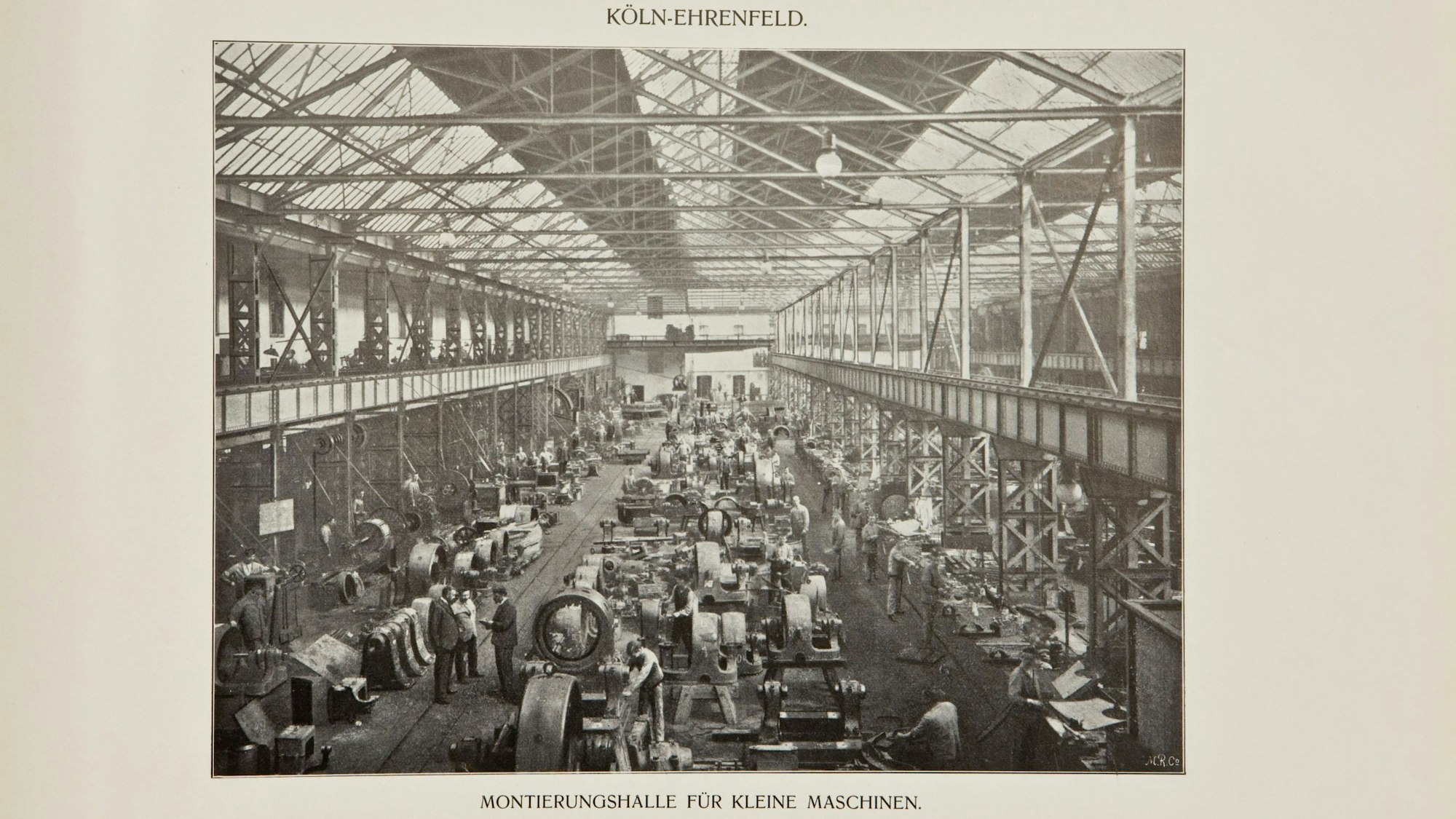 Auf einer historischen Aufnahme fertigen Menschen Anlagen in einer großen Halle.