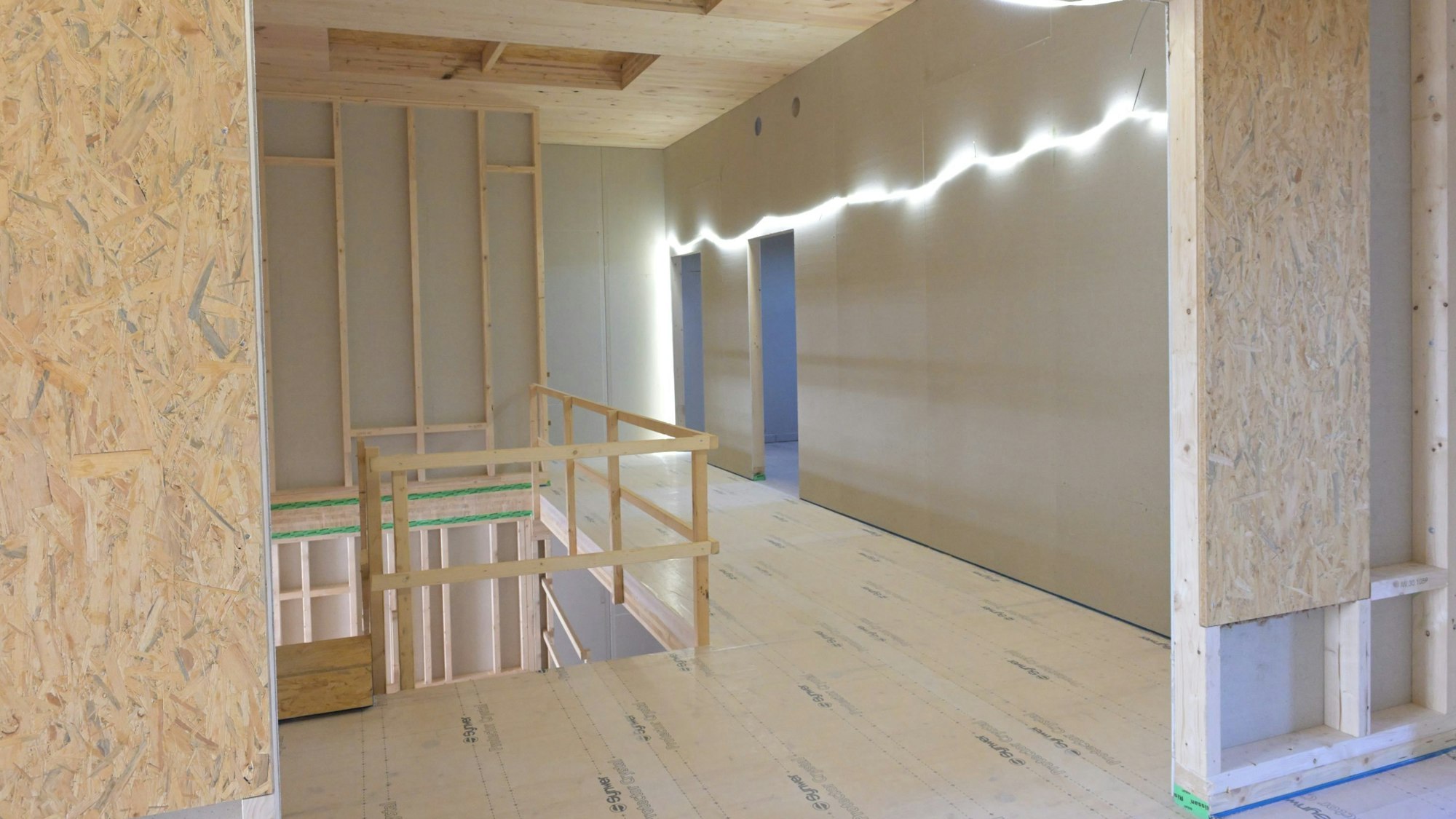 Man sieht das Treppenhaus mit den holzverschalten Wänden.