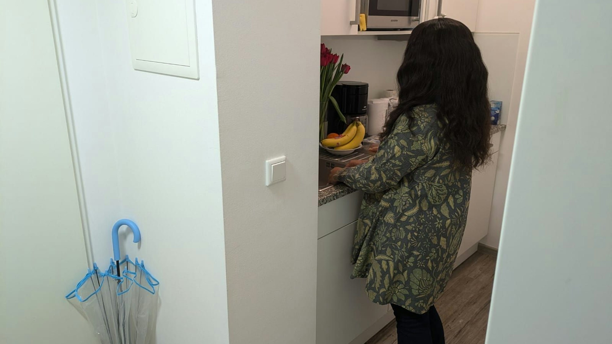 Eine junge Frau wäscht Geschirr ab.