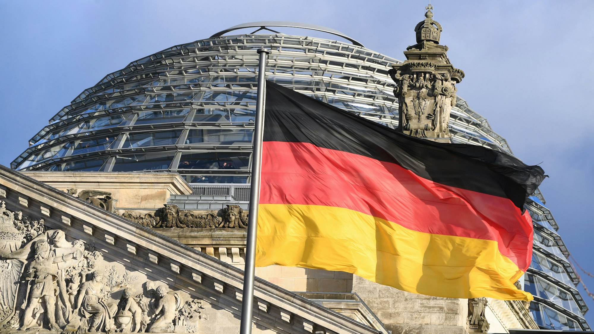 ARCHIV - 05.01.2017, Berlin: Die schwarz-rot-goldene Flagge weht vor der Kuppel des Reichstages. Foto: Soeren Stache/dpa +++ dpa-Bildfunk +++