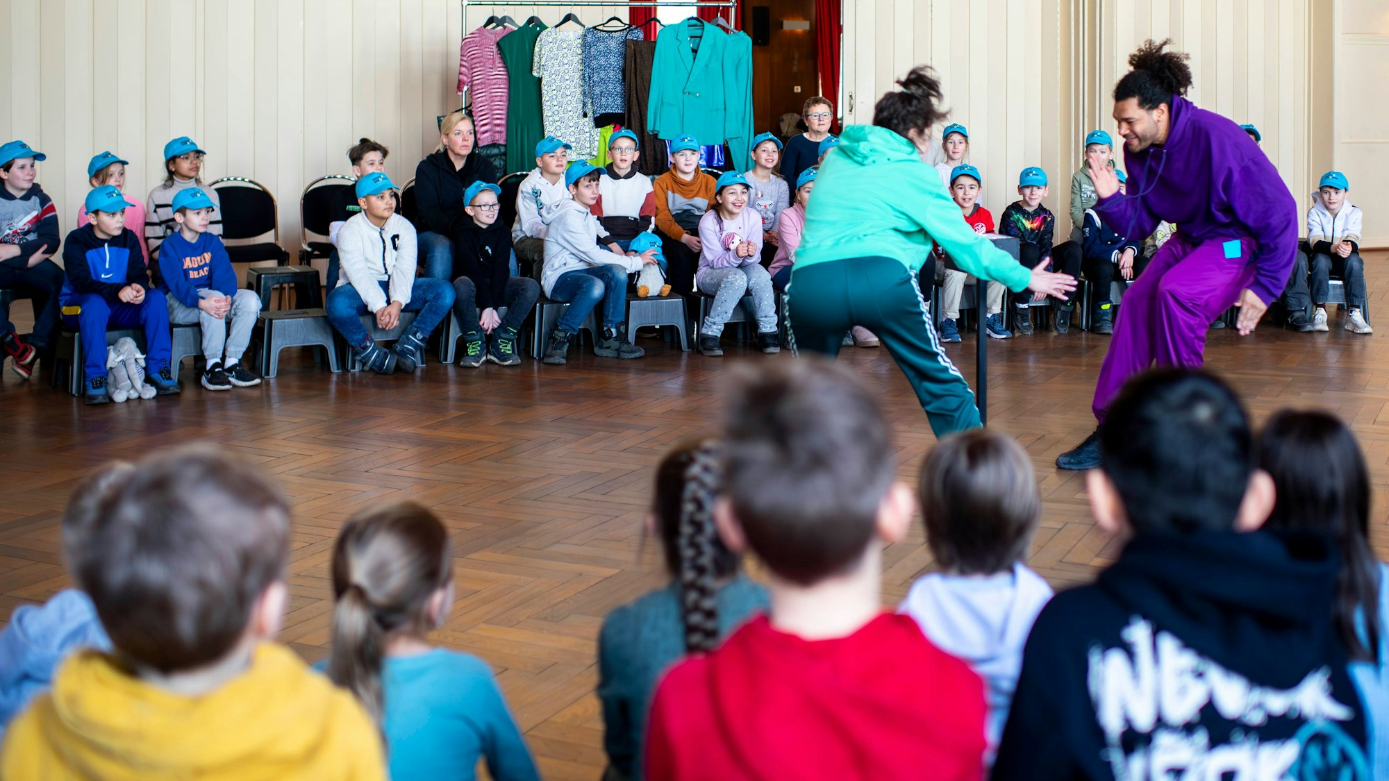 Das Bild zeigt die beiden Schauspieler im Euskirchener Casino während des Auftritts. Schüler verfolgen das Schauspiel gebannt.