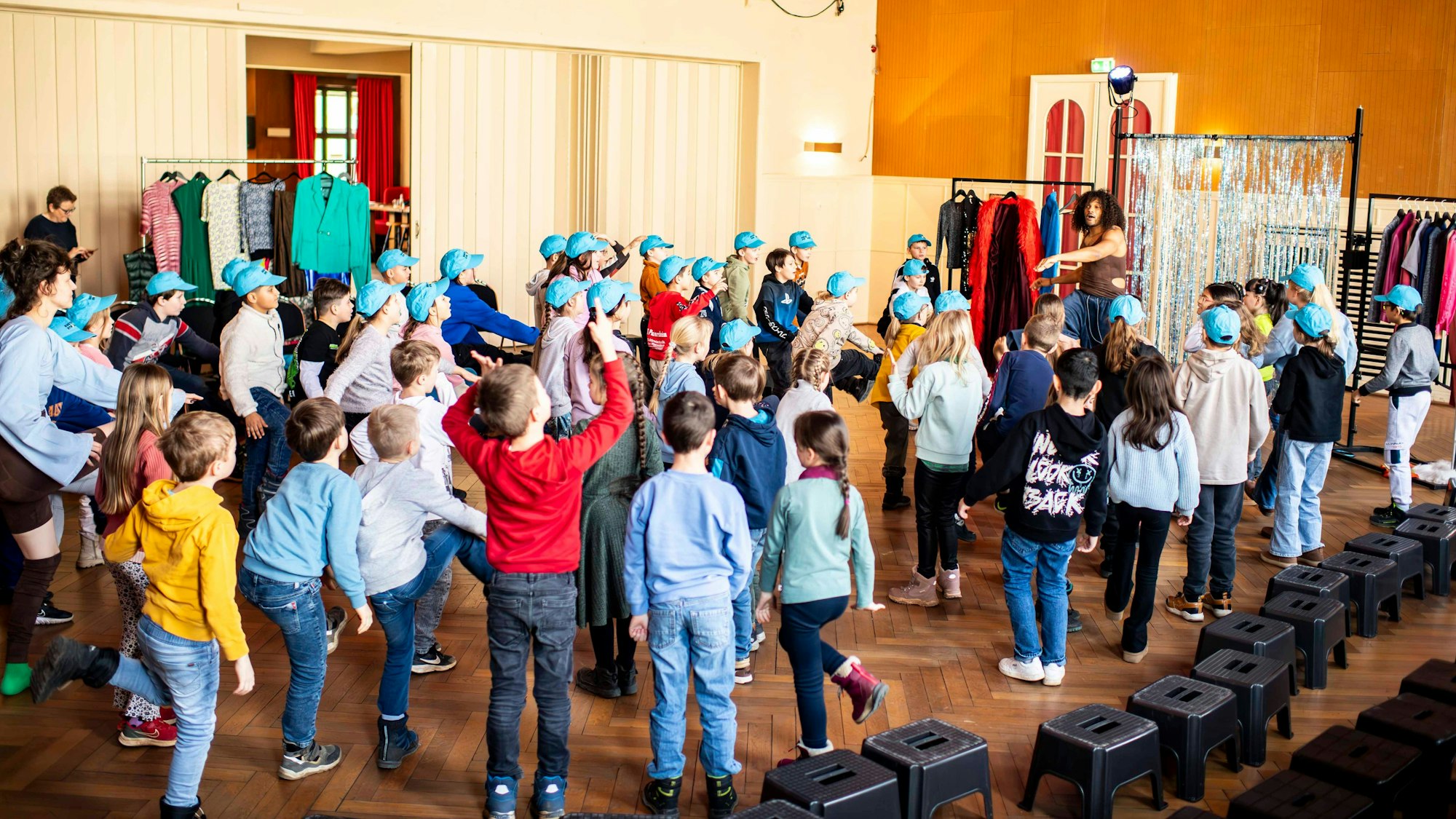 Das Bild zeigt zwei Schulklassen, die mit den Schauspielern gemeinsam tanzen.