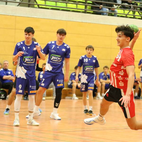 Ein Spieler der HSG Euskirchen beim Sprungwurf, Gegner und Mitspieler schauen zu.