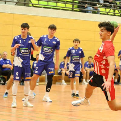 Ein Spieler der HSG Euskirchen beim Sprungwurf, Gegner und Mitspieler schauen zu.