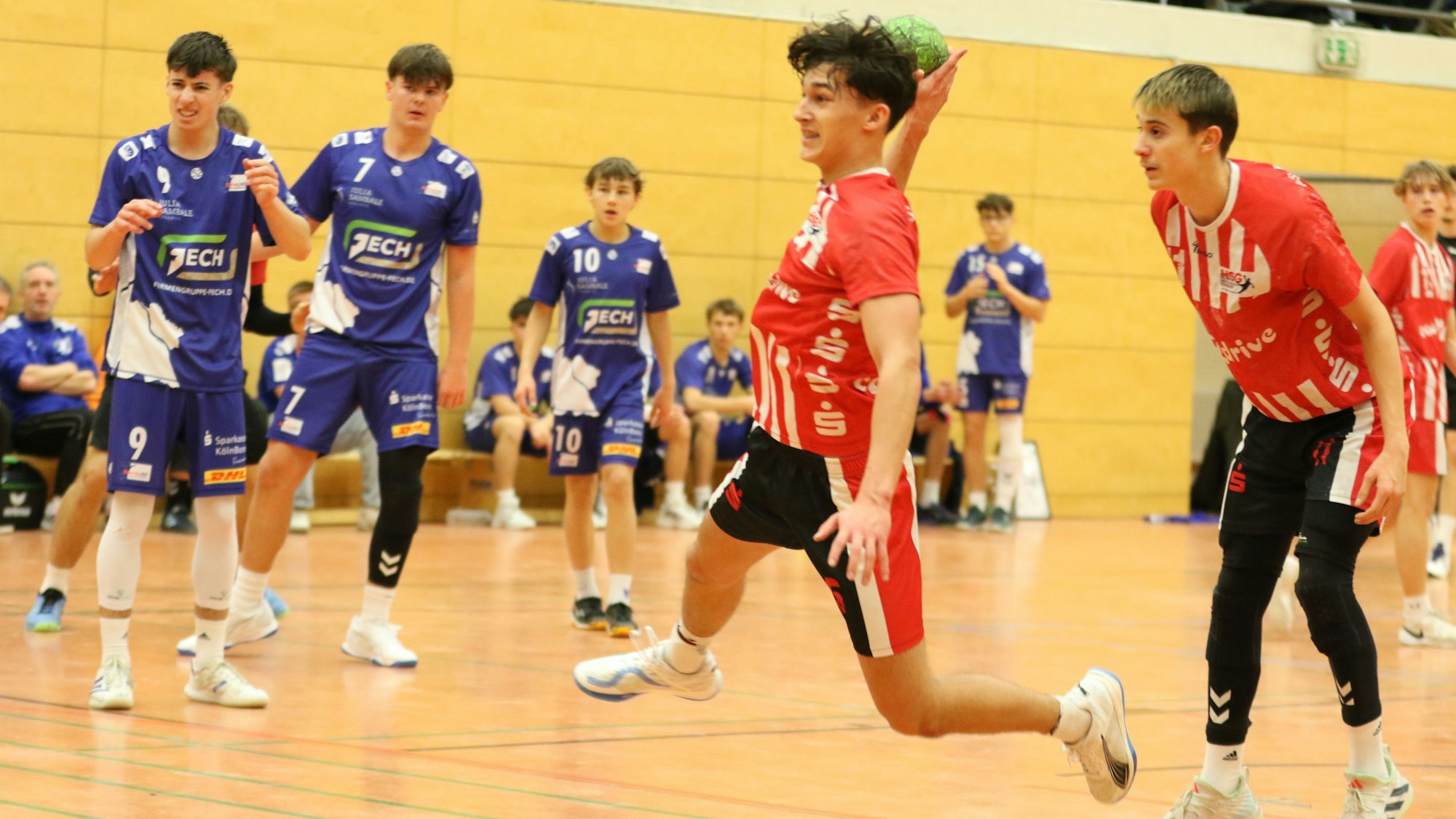 Ein Spieler der HSG Euskirchen beim Sprungwurf, Gegner und Mitspieler schauen zu.