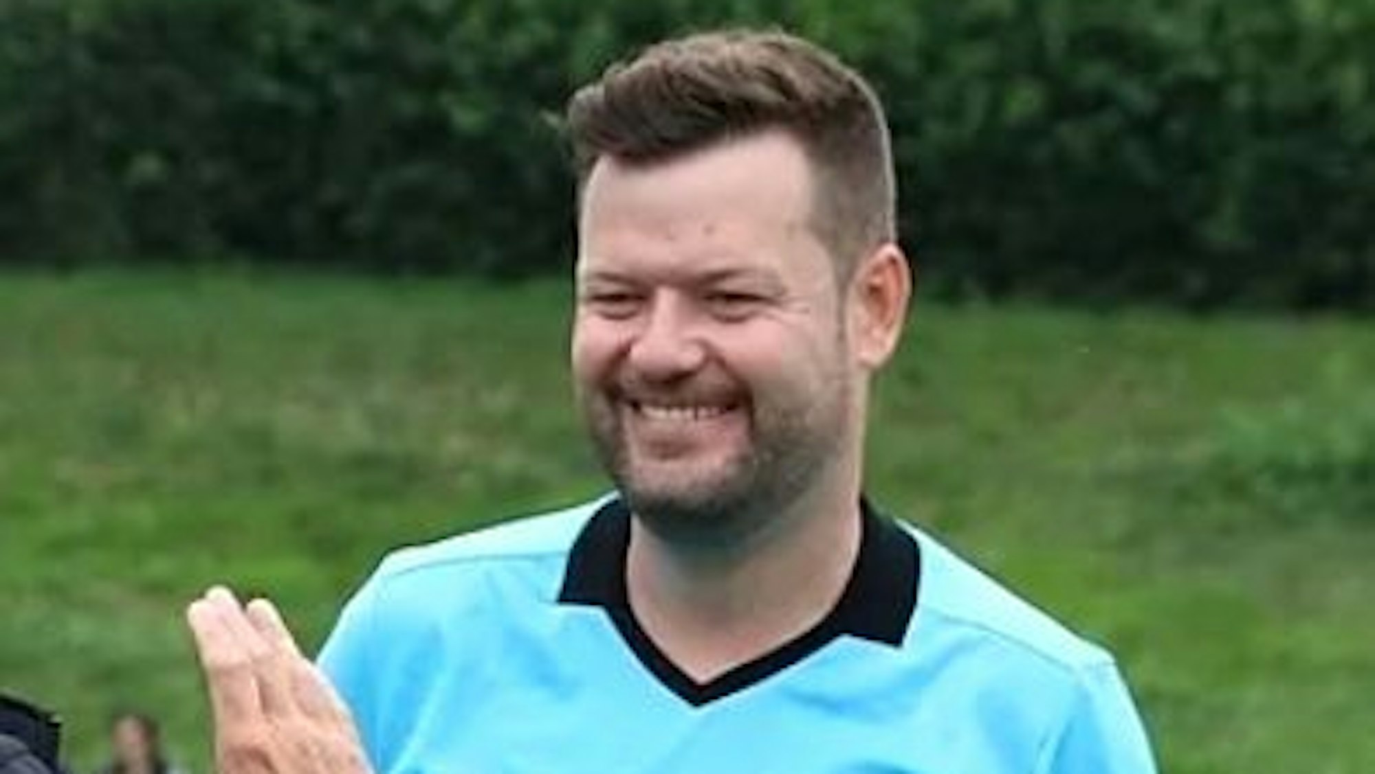 Ein Mann will Schiedsrichter Michael Erken die Hand geben. Der lacht.