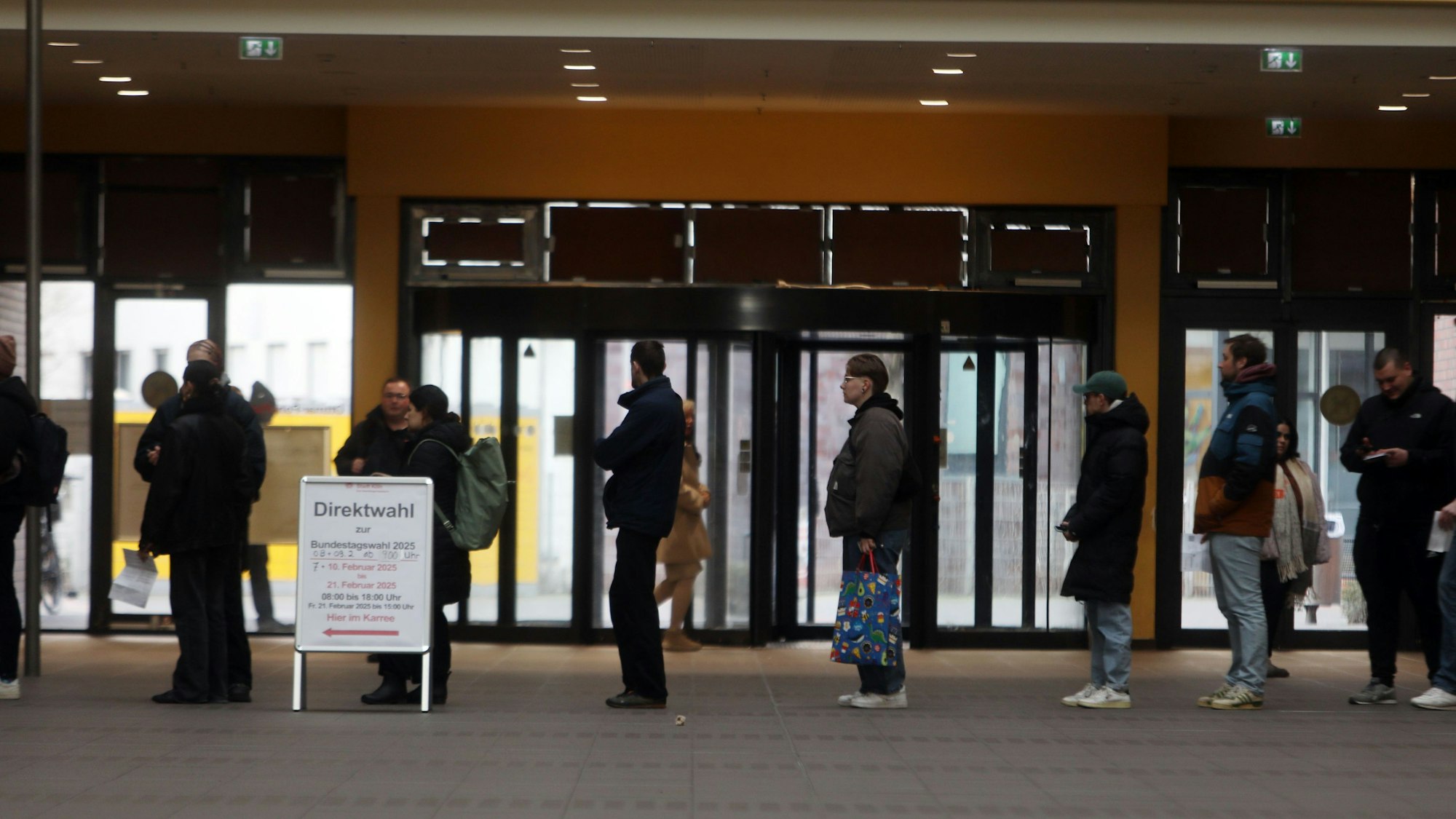 Zu sehen ist eine Ansammlung von Menschen, die für die Direktwahl in Kalk ansteht.