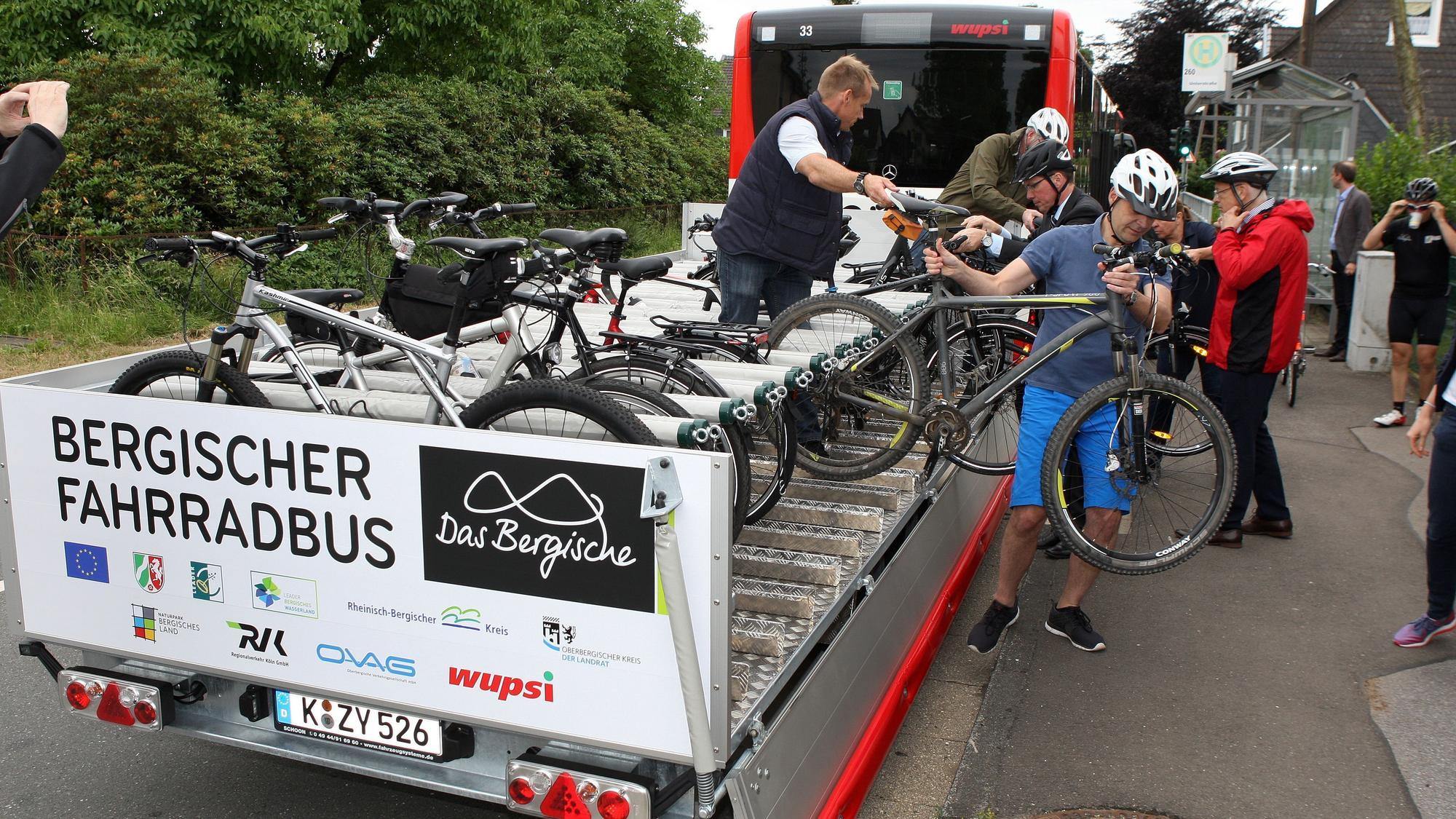 Fahrradfahrer laden Räder auf den Anhänger eines Bergischen Fahrradbusses in Wermelskirchen.
