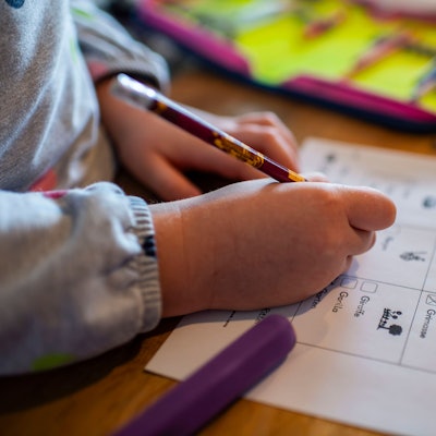 Das Bild zeigt eine Grundschülerin, die ein Arbeitsblatt bearbeitet.