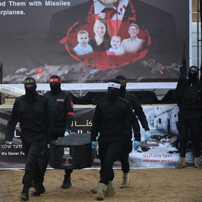 Palestinian militants carry one of the four coffins during the handing over of the bodies of four Israeli hostages to the Red Cross in Khan Yunis in the southern Gaza on February 20, 2025. Hamas handed over on February 20 coffins believed to contain the bodies of four Israeli hostages, including those of the Bibas family who became symbols of the ordeal that has gripped Israel since the Gaza war began. The transfer of the bodies is the first by Hamas since its October 7, 2023 attack on Israel triggered the war, and is taking place under a fragile ceasefire that has seen living hostages exchanged for Palestinians held in Israeli prisons. (Photo by Eyad BABA / AFP)