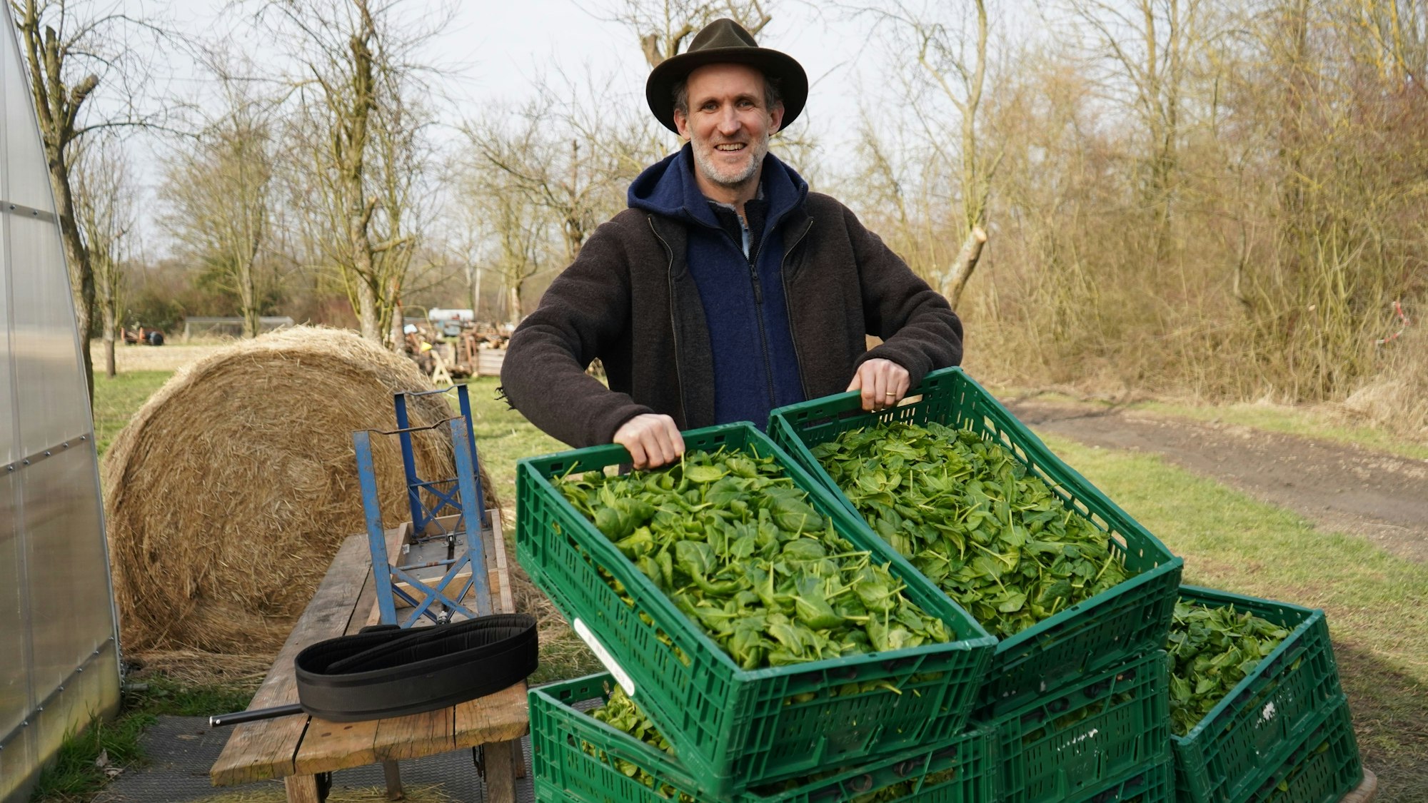 Das Foto zeigt Severin von Hoensbroech, der Kisten mit Spinat zeigt.