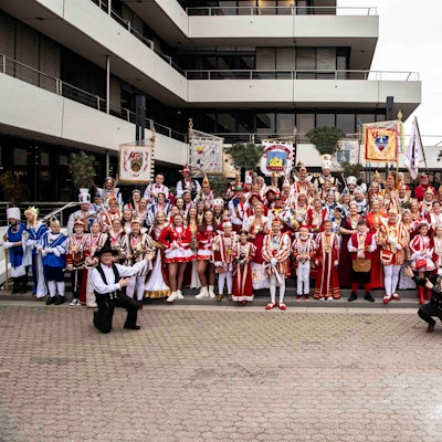 Zahlreiche Karnevalstollitäten stehen auf der Treppe vor dem Kreishaus in Euskirchen. Rechts vor der Gruppe kniet Landrat Markus Ramers in einem Schornsteinfeger-Kostüm.