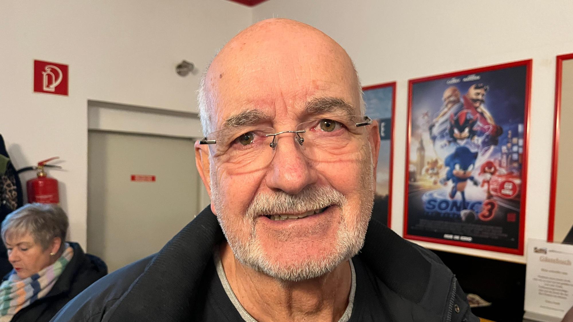 Ein Mann steht in einem Kino im Foyer.