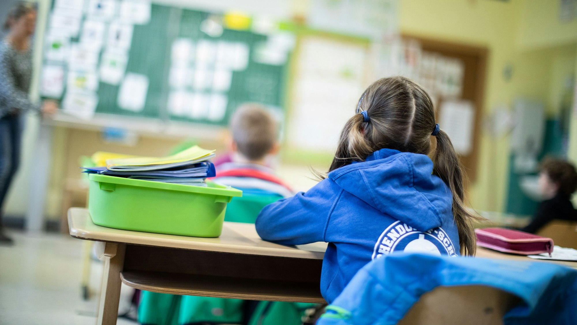 Schülerinnen und Schüler einer Grundschule sitzen mit Abstand in ihrem Klassenraum.