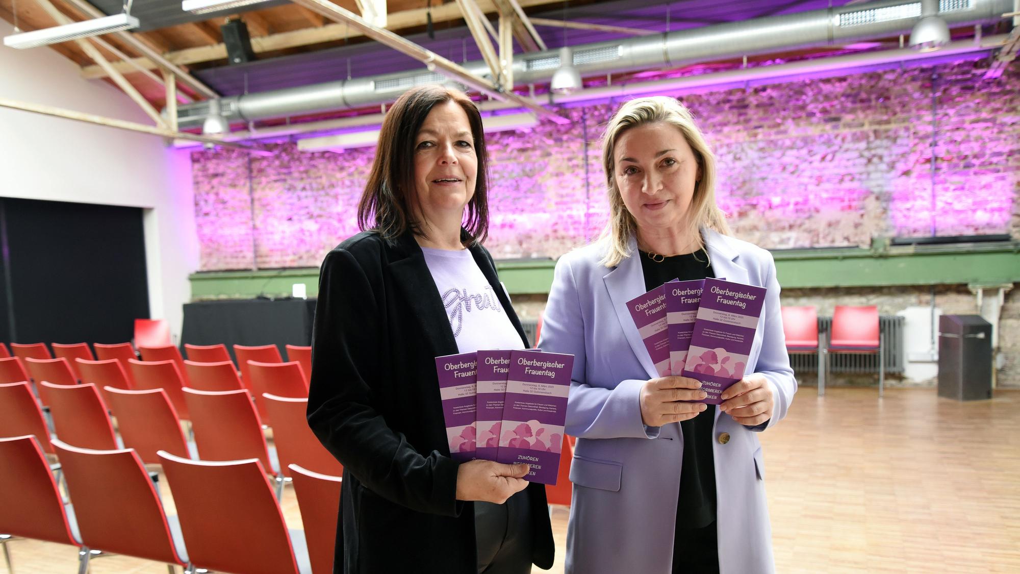 Zwei Frauen halten Flyer in der Hand.