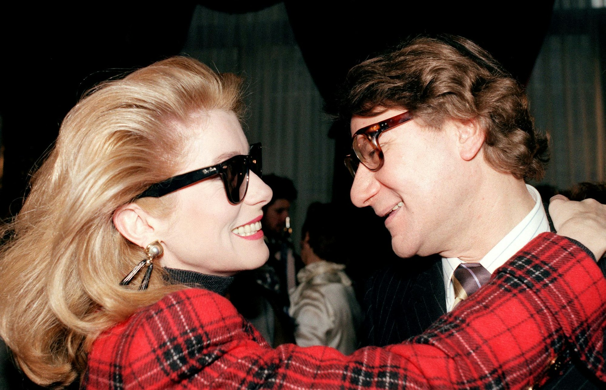 Catherine Deneuve und Yves Saint Laurent nach einer Modenschau 1987.