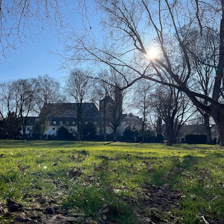 Der Max-Dietlein-Park mit der Kirche Sankt Pantaleon im Hintergrund.