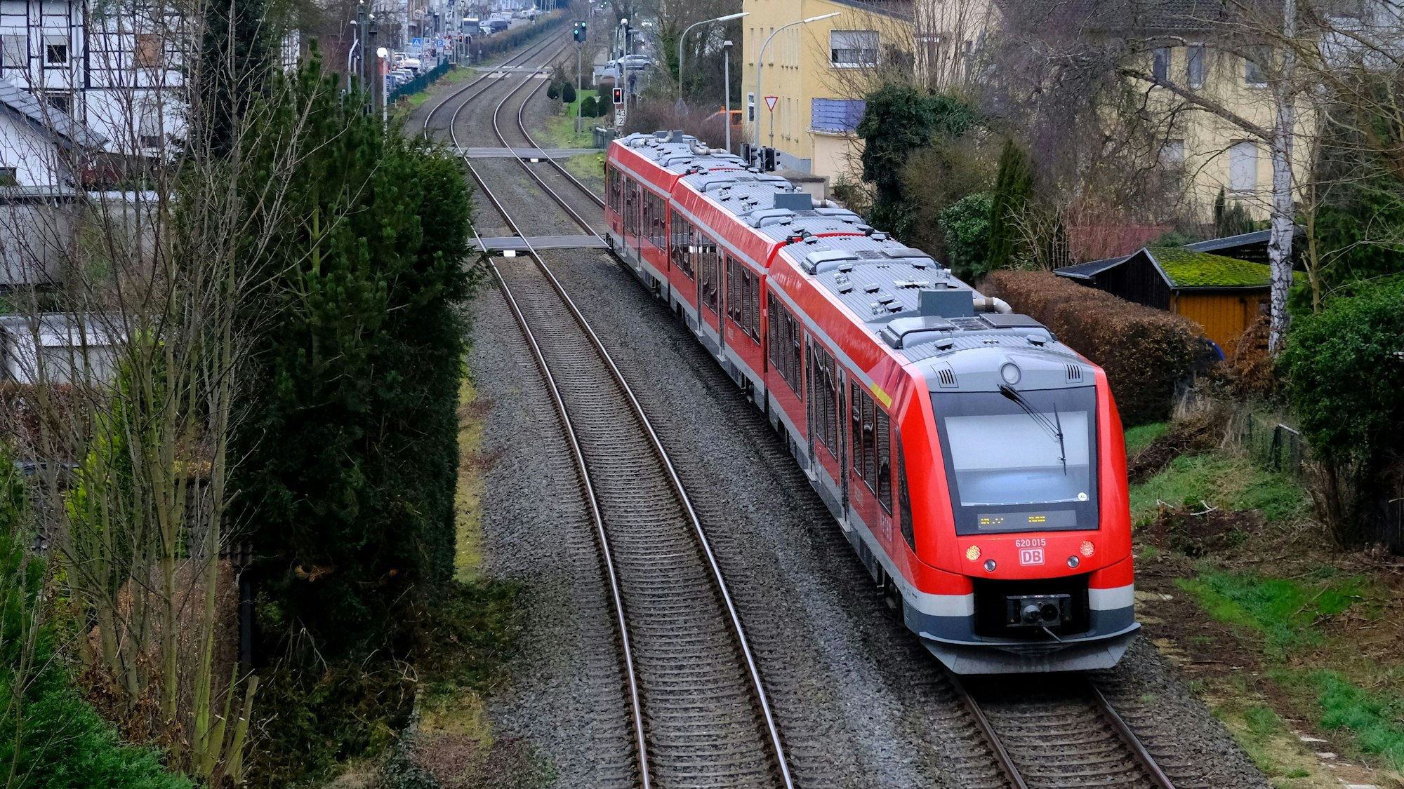 Ein roter Vareo-Nahverkehrszug befährt die Eifelstrecke bei Mechernich.