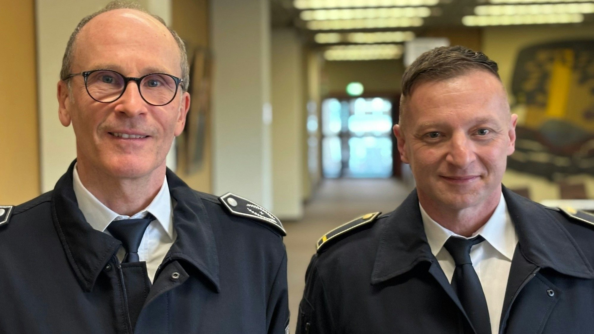 Auf dem Bild sind der Leiter der Feuerwehr und sein Stellvertreter in Uniform im Rathaus zu sehen.