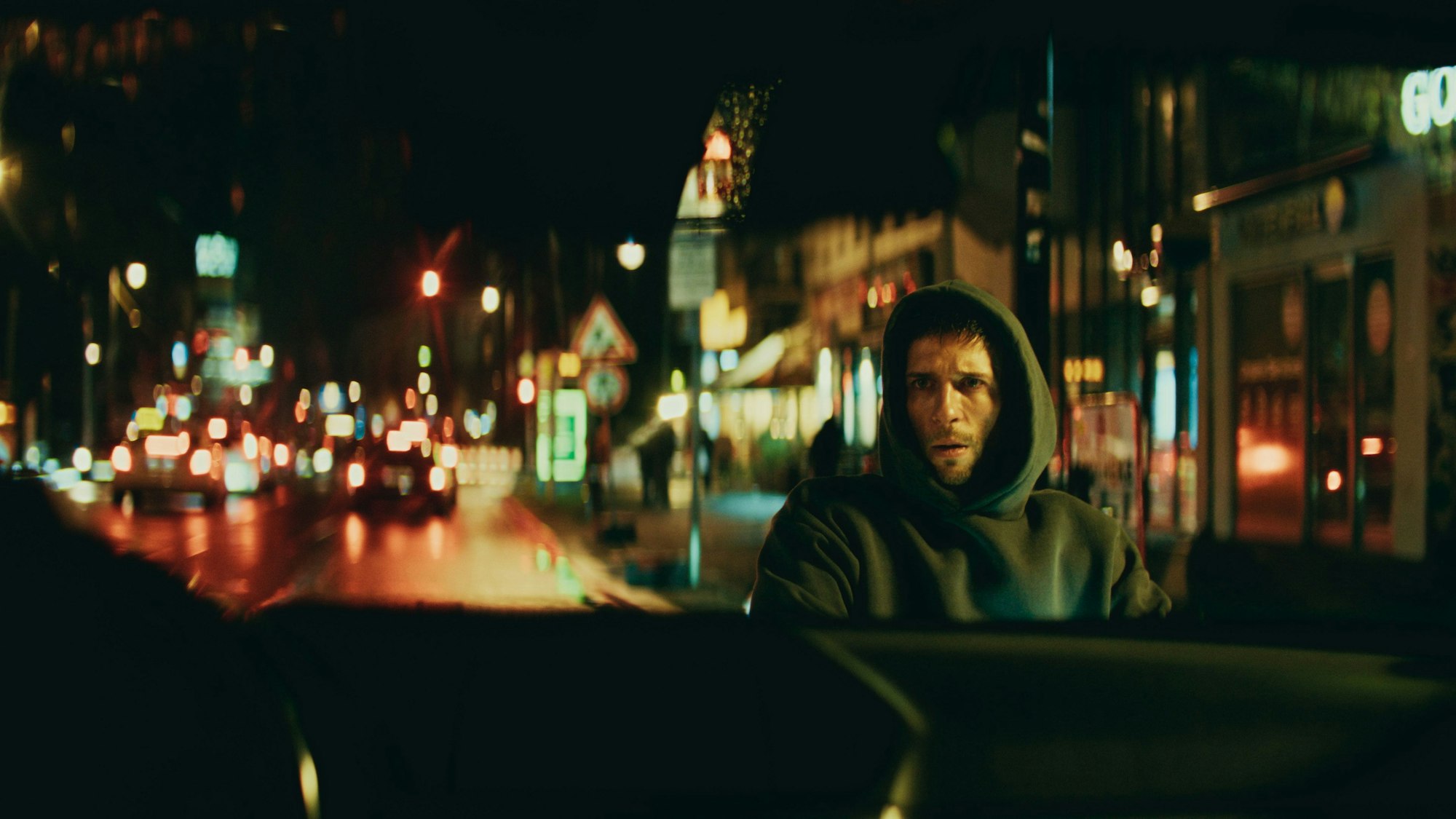 Slavko Popadić mit Kapuzenpullover nachts auf den Straßen Berlins.