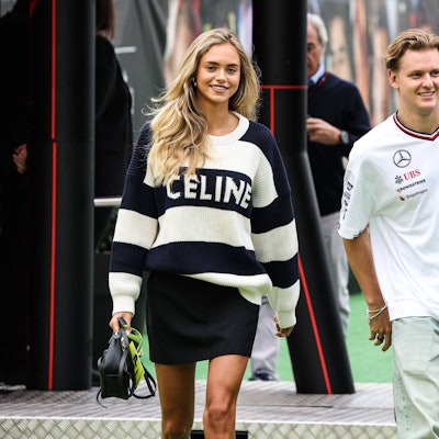 Mick Schumacher und seine Freundin Laila Hasanovic betreten das Fahrerlager.