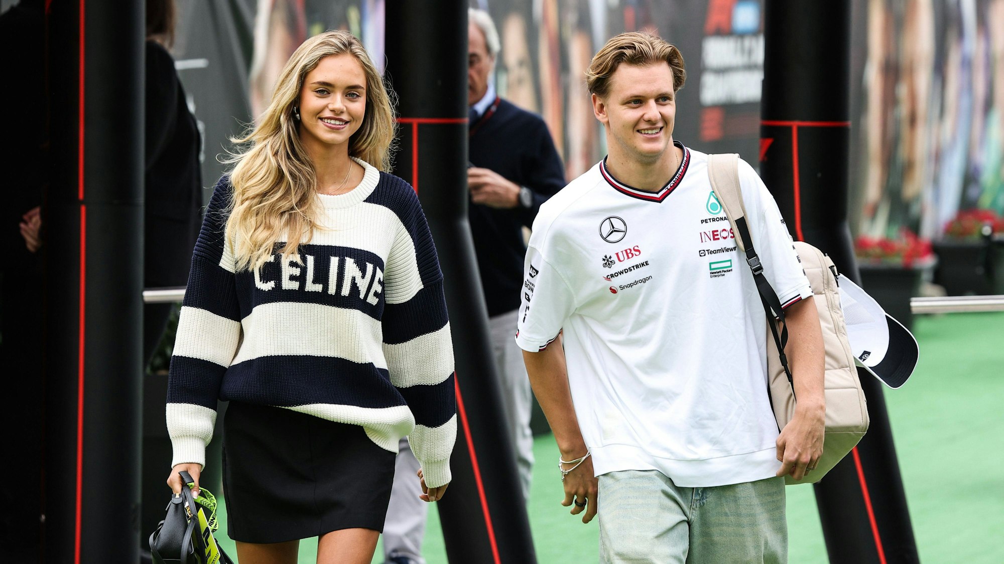 Mick Schumacher und seine Freundin Laila Hasanovic betreten das Fahrerlager.