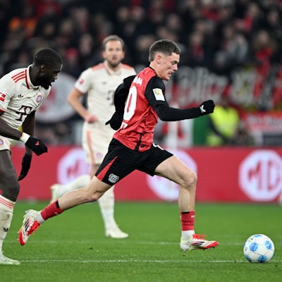 15.02.2025, Nordrhein-Westfalen, Leverkusen: Fußball: Bundesliga, Bayer Leverkusen - Bayern München, 22. Spieltag, BayArena, Leverkusens Florian Wirtz (r) und Bayerns Dayot Upamecano kämpfen um den Ball. Foto: Federico Gambarini/dpa - WICHTIGER HINWEIS: Gemäß den Vorgaben der DFL Deutsche Fußball Liga bzw. des DFB Deutscher Fußball-Bund ist es untersagt, in dem Stadion und/oder vom Spiel angefertigte Fotoaufnahmen in Form von Sequenzbildern und/oder videoähnlichen Fotostrecken zu verwerten bzw. verwerten zu lassen. +++ dpa-Bildfunk +++
