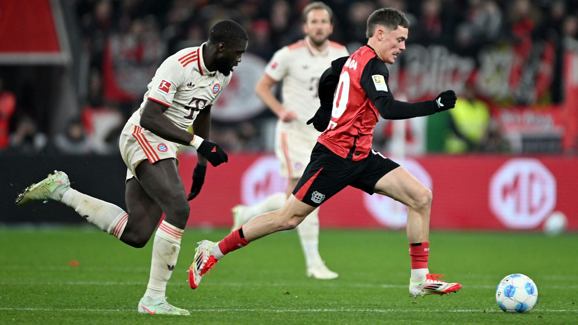 15.02.2025, Nordrhein-Westfalen, Leverkusen: Fußball: Bundesliga, Bayer Leverkusen - Bayern München, 22. Spieltag, BayArena, Leverkusens Florian Wirtz (r) und Bayerns Dayot Upamecano kämpfen um den Ball. Foto: Federico Gambarini/dpa - WICHTIGER HINWEIS: Gemäß den Vorgaben der DFL Deutsche Fußball Liga bzw. des DFB Deutscher Fußball-Bund ist es untersagt, in dem Stadion und/oder vom Spiel angefertigte Fotoaufnahmen in Form von Sequenzbildern und/oder videoähnlichen Fotostrecken zu verwerten bzw. verwerten zu lassen. +++ dpa-Bildfunk +++